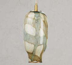 a green and white vase hanging from a ceiling light with a gold colored cord attached to it