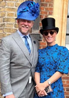 a man in a suit and tie standing next to a woman wearing a blue dress