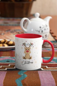 two coffee mugs sitting on top of a table next to cookies and muffins