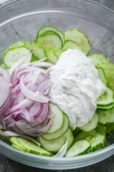 cucumber and onion salad with ranch dressing in a glass bowl on the table