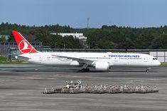 an airplane that is sitting on the tarmac with other planes in front of it