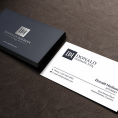 a black and white business card sitting on top of a brown leather surface with the letter p