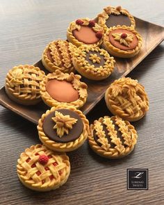 small pies are arranged on a wooden tray