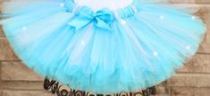 "A stunning, fluffy turquoise blue and silver glitter tutu All tutus are made with high quality tulle and a 1\" non-roll waist band.  I make all my tutus very full and fluffy.  I put as much tulle as I can possibly fit. Each tutu has a matching bow attached. When measuring your child's waist, order the size that is 2 inches smaller than her actual waist since the band is made of elastic. Tutu Size Chart 0-6 mo         14\" waist    6\"length 6-12 mo       15\"waist     6\"length 12-24 mo     16\ Princess Style Light Blue Tulle Tutu Dress, Blue Tulle Skirt Tutu Dress For Birthday, Tutu Size Chart, Tutu Shirt, Girls Clothing Sets, Clothing Sets, Girls Clothing, Silver Glitter, Waist Band