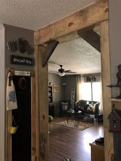 an open doorway leading to a living room with wood floors and furniture on the other side