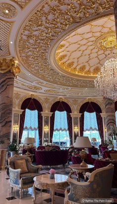 an ornately decorated living room with chandelier and couches in the center