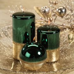 two green candles sitting on top of a glass plate