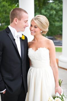 a bride and groom standing next to each other in front of a white building with columns