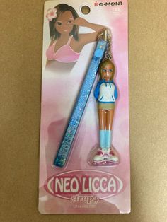 a plastic keychain with a girl holding a pen in it's hand