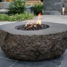 a fire pit sitting on top of a stone walkway