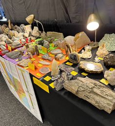 a table topped with lots of rocks and paper on top of it's sides