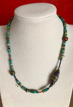 Eclectic Turquoise Necklace w/ handmade beads from Nepal. Largest bead is 1 1/4" x 3/8". Natural Vintage Inlaid Coral Bead. Common practice in Nepal was to fill the cracks and crevasses of old coral beads with bronze, turquoise, lapis and coral. These beads have become very rare and hard to find. Very unique necklace. I also mixed in a variety of other coral and brass beads. Brass Hook Clasp. Upon request I can custom make this necklace or any other necklace in my store longer. I will quote a pr Artisan Hand-strung Turquoise Necklace For Festivals, Artisan Beaded Turquoise Necklace, Traditional Handmade Turquoise Beaded Necklaces, Bohemian Blue Turquoise Necklace With Round Beads, Spiritual Turquoise Necklace With Round Beads For Festivals, Bohemian Blue Turquoise Beaded Necklace, Bohemian Blue Turquoise Necklace, Artisan Hand-strung Turquoise Necklace With Round Beads, Hand-strung Turquoise Beaded Necklaces With Round Beads