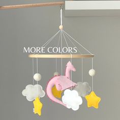 a mobile that says more colors with a pink elephant on it and stars hanging from the strings