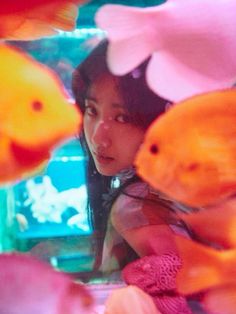 a woman looking at fish in an aquarium