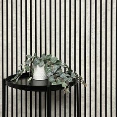 a black table topped with a white vase filled with plants