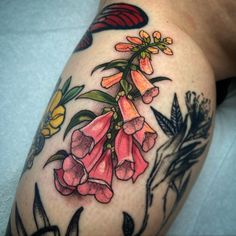 a close up of a tattoo with flowers on it