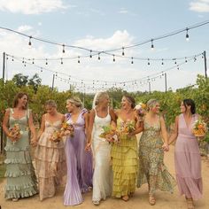 a group of women standing next to each other in front of a string of lights