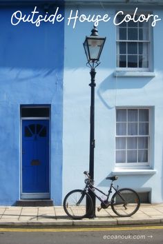 a bicycle parked next to a blue building with the words outside house colors on it