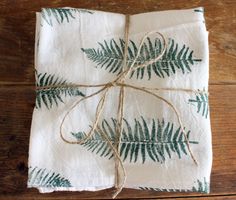 the napkins are wrapped in twine and have green leaves on them