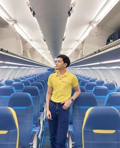 a man standing in the aisle of an airplane with his hand on his hip and looking off into the distance