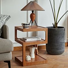 a living room with a couch, table and lamp on it's side stand