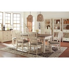 a dining room table with chairs and a rug