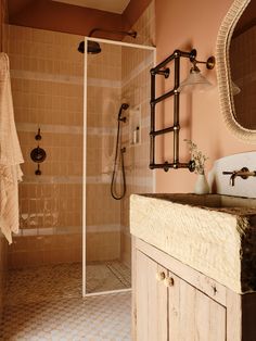 a bathroom with a walk in shower next to a sink and a wooden counter top