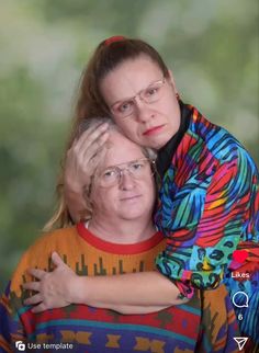 two women hugging each other with trees in the background