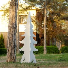 a white wooden christmas tree sitting in the grass