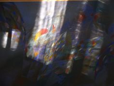 blurry photograph of an abstract painting with blue, yellow and red colors on it