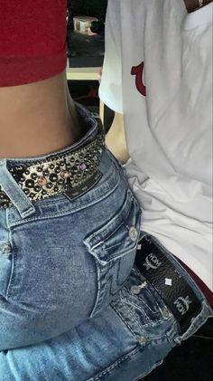 the back of a person's jeans with an embellishment on their waist