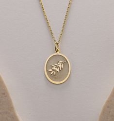 Gold Olive Tree Pendant - Olive Tree Branch Leaf Gold Necklace ● Material of pendant: Solid Gold 14k ( REAL GOLD ) ● Metal Stamp: 14k ( REAL GOLD ) ● The pendant is available in 5 sizes: - 12x17 mm / 0,47 x 0,66 inches - 13x18 mm / 0,51 x 0,70 inches  In the photos - 14x19 mm / 0,55 x 0,74 inches  - 16x21 mm / 0,62 x 0,82 inches  - 18x24 mm / 0,70 x 0,94 inches ( In the photos the size is 13x18 mm / 0,51 x 0,70 inches ) ( Jump Ring inner diameter: 4 mm ) ● Material of chain: Solid gold 14k ( REAL GOLD ) It is thin and dainty and it is available in 4 sizes: - 40 cm / 15,75 inches ( Length ) - 45 cm / 17,72 inches ( Length ) In the photos - 50 cm / 19,68 inches ( Length ) - 55 cm / 21,65 inches ( Length ) ● Backside engraving is FREE ( Please use the personalization box for that.) ● If you w Commemoration Pendant Necklaces With Charms, Commemorative Pendant Necklaces With Charms, Commemorative Pendant Necklace With Charms, Silver Charm Necklace Stamped 14k As Gift, Gift Silver Charm Necklace Stamped 14k, Oval Charm Necklaces As Gift, Yellow Gold Oval Charm Necklace As Gift, Yellow Gold Oval Charm Necklace Gift, Oval Charm Necklaces For Gifts