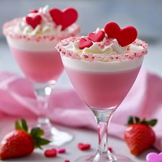 two glasses filled with pink liquid and topped with hearts