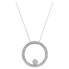 Embrace the captivating radiance of this stunning circular pendant. Crafted in lustrous 14k white gold, it showcases a mesmerizing arrangement of pave-set round brilliant cut diamonds. The dazzling ensemble of diamonds, weighing a total of 1.10 carats, creates a breathtaking display of brilliance. Each diamond possesses an H-I color, emanating a warm glow while maintaining a remarkable VS2-SI1 clarity overall. Adding a touch of distinction, a larger bezel-set round brilliant cut diamond, weighin White Gold Diamond Necklace With Round Platinum Pendant, White Gold Diamond Necklace With Round Pendant, Timeless Round Diamond Necklace With Halo, Dazzling Platinum Diamond Necklace With Round Pendant, Round Platinum Diamond Necklace, White Gold Circle Diamond Necklace Fine Jewelry, 14k White Gold Brilliant Cut Necklace, 14k White Gold Round Brilliant Cut Necklace, Round Platinum Diamond Necklace Gift