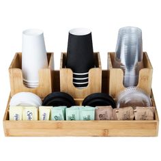 a bamboo tray with cups, plates and napkins in it on a white background