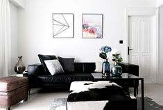 a black and white living room with cow hide rugs on the floor in front of it