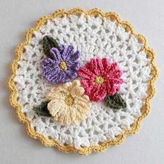 a crocheted doily with three flowers on the bottom and one flower in the middle