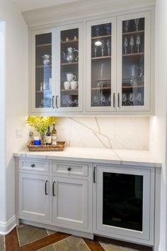 a kitchen with white cabinets and marble counter tops, along with an oven in the center