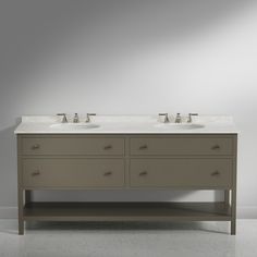 two sinks are shown in front of a gray wall with white tiles on the floor