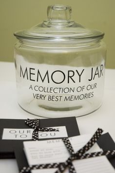 a glass jar sitting on top of a table next to some cards and tags in front of it