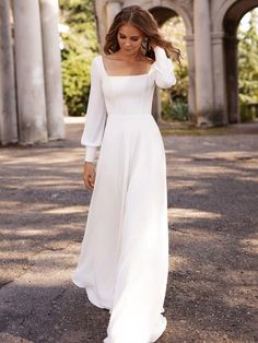 a woman in a white dress is walking down the street with her hand on her head