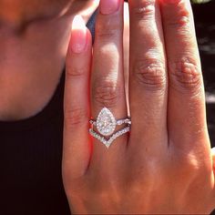 a close up of a person's hand with a diamond ring on her finger