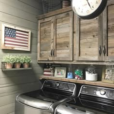 a washer and dryer in a small room with wooden cabinets on the wall