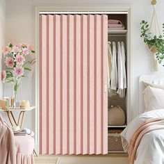 a bedroom with pink striped curtains and white bedding in front of the closet door