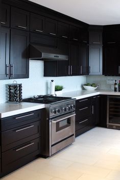 a kitchen with black cabinets and stainless steel appliances