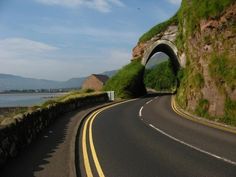 a curved road with a tunnel on the side