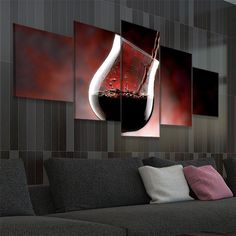 a wine glass with red liquid in it hanging on a wall next to a couch