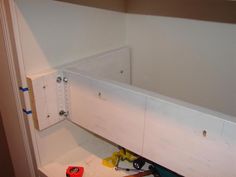 the inside of a room with tools and construction materials on the floor, including an open cabinet door