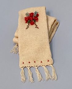 "This is a handmade knitted scarf. It is cream colored with a very slight yellow tint. The scarf has been folded in half lengthwise and sewn together, making it extra warm for cold winter days and nights. The hand embroidery consists of clusters of red flowers with a bit of light yellow mixed in. There are also some vines embroidered in dark green with small red flower buds on them. All embroidery is stitched with wool yarn, and is on one end of the scarf, showing on one side.  There are five small red beads knit into both ends of the scarf, showing on one side. Ten beads in all. The length is 57\" and width is 6\". It is made from Mohair Wool/Acrylic blend yarn and has been washed and conditioned." Hand Embroidery Christmas, Girls Winter Hats, Bead Knit, Mohair Scarf, Small Business Gifts, Knit Scarves, Christmas Scarf, Embroidery Christmas, Etsy Stuff