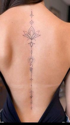 the back of a woman's neck with a flower tattoo on her lower back